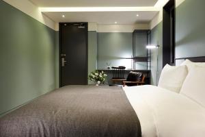 a bedroom with a large bed and a table at 9 Brick Hotel in Seoul