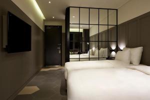 a hotel room with two beds and a television at 9 Brick Hotel in Seoul