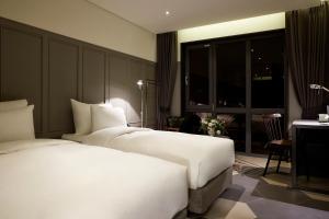 a hotel room with two beds and a desk at 9 Brick Hotel in Seoul