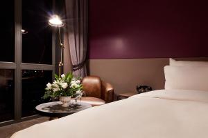 a hotel room with a bed and a table with flowers at 9 Brick Hotel in Seoul