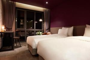 a hotel room with two beds and a window at 9 Brick Hotel in Seoul