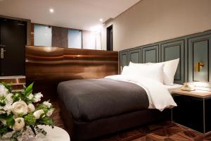 a bedroom with a bed and a table with flowers at 9 Brick Hotel in Seoul