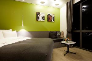 a bedroom with a bed and a table and some paintings at 9 Brick Hotel in Seoul