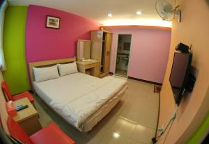 1 dormitorio con 1 cama y una pared colorida en ZaiXiang en Danshui