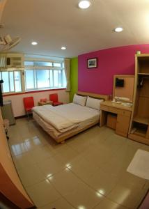 a bedroom with a bed and a pink and green wall at ZaiXiang in Tamsui