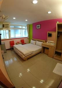 1 dormitorio con 1 cama y una pared rosa y verde en ZaiXiang en Danshui