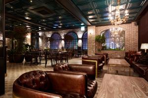 a restaurant with leather furniture and tables and chairs at 9 Brick Hotel in Seoul