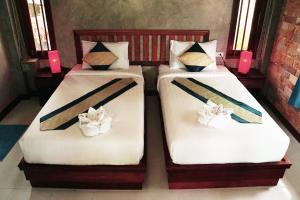 two beds in a room with candles on them at Wonderland Healing Center in Thongsala
