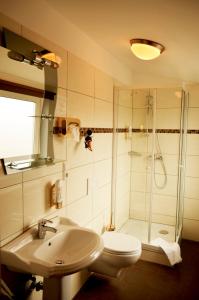 ein Bad mit einem WC, einem Waschbecken und einer Dusche in der Unterkunft AS Hotel in Göttingen