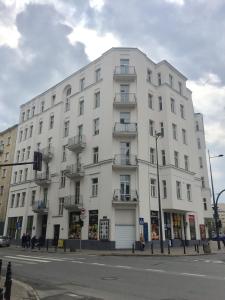 biały budynek na rogu ulicy w obiekcie Apartament Żelazna w Warszawie