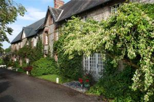 a house with ivy growing on the side of it at La Verte Campagne - 50660 Trelly in Trelly