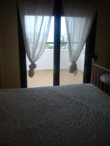 モラ・カリヴァにあるVilla Anastasia Skioniのベッドルーム1室(ベッド1台付)、窓(カーテン付)
