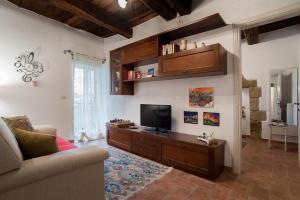 ein Wohnzimmer mit einem Sofa und einem TV in der Unterkunft Casetta Nella Fratta in Pitigliano