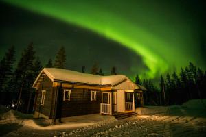 Eine Hütte mit der Aurora im Himmel in der Unterkunft Valkea Arctic Lodge in Pello