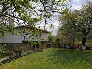 una casa con un patio con un árbol y una valla en Complex Ovchaga en Asparukhovo