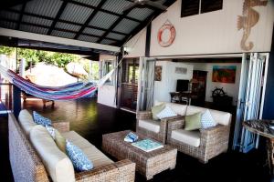 ein Wohnzimmer mit Sofas und einer Hängematte in der Unterkunft Bedarra Beach House in Bedarra Island