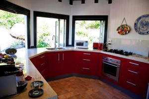 eine Küche mit roten Schränken und einem Herd mit Backofen in der Unterkunft Bedarra Beach House in Bedarra Island