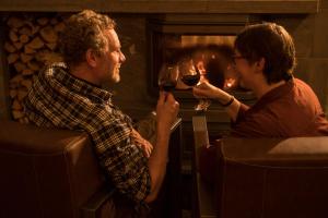 Ein Mann und eine Frau trinken Wein vor einem Kamin. in der Unterkunft Valkea Arctic Lodge in Pello