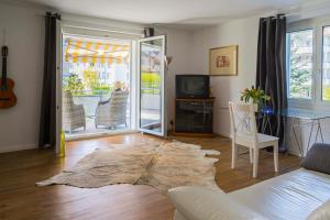 ein Wohnzimmer mit einem Sofa und einem TV in der Unterkunft Konstanz nähe, ruhiges 4-Zim-Wohnung bis 8 Personen in Kreuzlingen