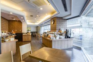 a restaurant with tables and chairs and a counter at Hotel Route-Inn Tokyo Ikebukuro in Tokyo