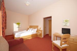 a hotel room with a bed and a desk at Hotel Pariente in Schladming