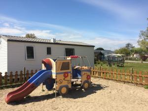 un parque infantil con un tobogán en un patio en Camping de la Plage en Marck