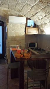 y cocina con mesa, sillas y fogones. en Cuore di Pietra B&B, en Polignano a Mare