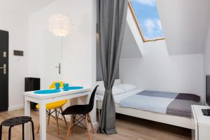 ヤロスワビエツにあるNadmorska Apartmentsの小さなベッドルーム(ベッド1台、テーブル、椅子付)