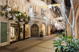 una calle comercial con luces de Navidad y árboles en Appartements Le Dome - Quartier Cathédrale, en Estrasburgo