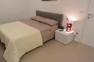 una camera da letto con un letto e una lampada sul comodino di Casa Manu a Misano Adriatico