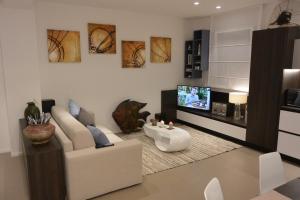 ein Wohnzimmer mit einem Sofa und einem TV in der Unterkunft Casa Manu in Misano Adriatico