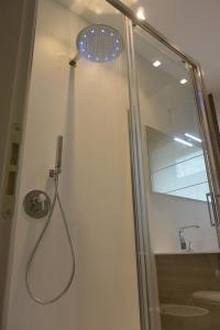 eine Dusche mit einer Glastür mit einem Duschkopf in der Unterkunft Casa Manu in Misano Adriatico