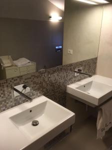 La salle de bains est pourvue d'un lavabo blanc et d'un miroir. dans l'établissement B&B Elda Country House, à Chiassa Superiore