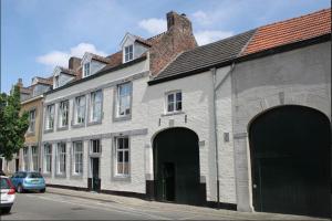 a white brick building with arches on a street at Artagnan in Maastricht