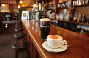 a cup of coffee and a drink on a bar at Killarney Riverside Hotel in Killarney
