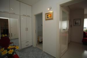 sala de estar con armarios blancos y sofá rojo en Iva Apartment Split, en Split