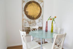 a dining room with a glass table and white chairs at Konstanz nähe, ruhiges 4-Zim-Wohnung bis 8 Personen in Kreuzlingen