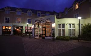 a hotel is lit up at night at Killarney Riverside Hotel in Killarney