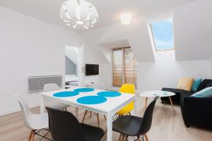 a dining room and living room with a table and chairs at Nadmorska Apartments in Jarosławiec