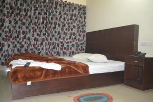 ein Schlafzimmer mit einem Bett mit einer braunen Decke darauf in der Unterkunft Dynamic SH Resort in Cox's Bazar