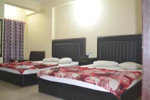 zwei Betten in einem Hotelzimmer mit zwei Betten in der Unterkunft Dynamic SH Resort in Cox's Bazar + 23 Fotos