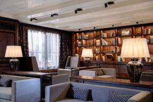 a waiting room with chairs and tables and bookshelves at Palazzo Veneziano - Venice Collection in Venice