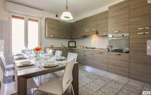 een keuken met een tafel met witte stoelen en een eetkamer bij Villa Maddalena in Scala