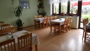 a dining room with tables and chairs in a restaurant at Pension U Dubu in Františkovy Lázně