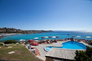 un complejo con piscina y playa con sombrillas en Club Esse Shardana en Santa Teresa Gallura