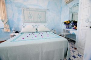 a bedroom with a white bed with flowers on it at Club Esse Shardana in Santa Teresa Gallura