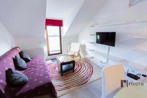 ヤシにあるCozy Apartment - Palasのリビングルーム(紫色のソファ、テレビ付)