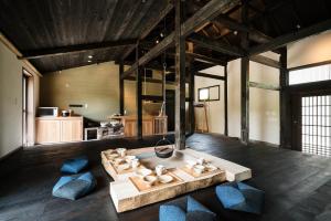 日南市にある季楽 飫肥のテーブルと青い椅子付きの広い客室です。