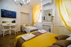 a bedroom with two beds and a table and a mirror at Sweet Life Trevi Roma in Rome