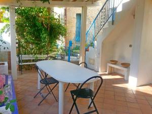 a white table and chairs on a patio with stairs at Il Fienile in Conca dei Marini